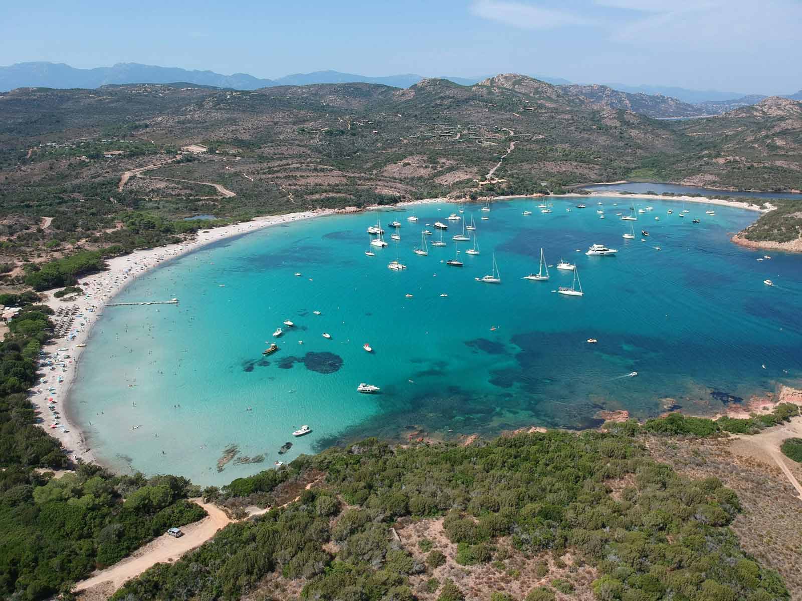 Plage de Rondinara en Corse, baie en forme de coquillage aux eaux turquoise et sable blanc