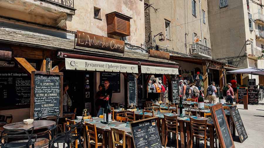 Terrasse animée du restaurant L'Auberge Corse dans le centre historique de Bonifacio, Corse