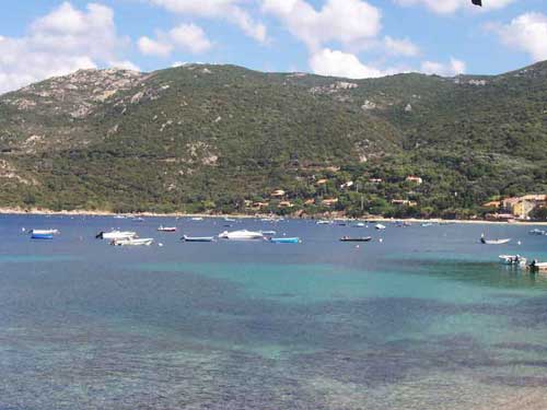 Bateaux ancrés dans la baie de Campomoro avec colline verdoyante en arrière-plan, en Corse-du-Sud