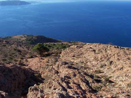 Relief rocheux aride dominant la mer au Capo Rosso, sur la côte ouest de la Corse