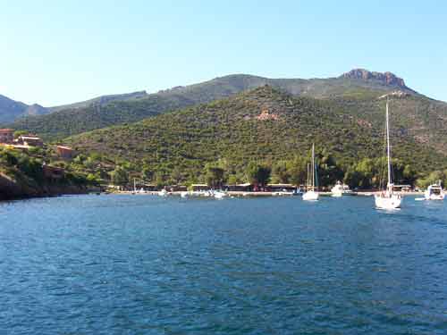 Port de Girolata avec voiliers et collines verdoyantes, village isolé en Corse