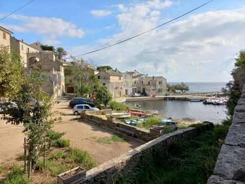Petit port de Porticciolo sur la côte est du Cap Corse, entouré de maisons anciennes et de barques