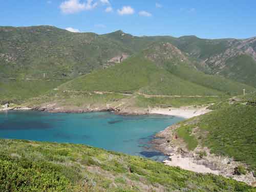 Vue panoramique sur l’anse d’Alisu, crique sauvage aux eaux turquoise nichée entre les collines verdoyantes du Cap Corse