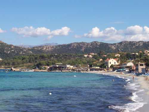 Plage de sable fin à L'Île-Rousse, bordée par les collines verdoyantes de Balagne, en Corse du Nord