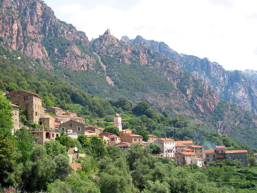 Village d’Ota en Corse, niché au pied des montagnes, avec ses maisons en pierre et son clocher rose typique