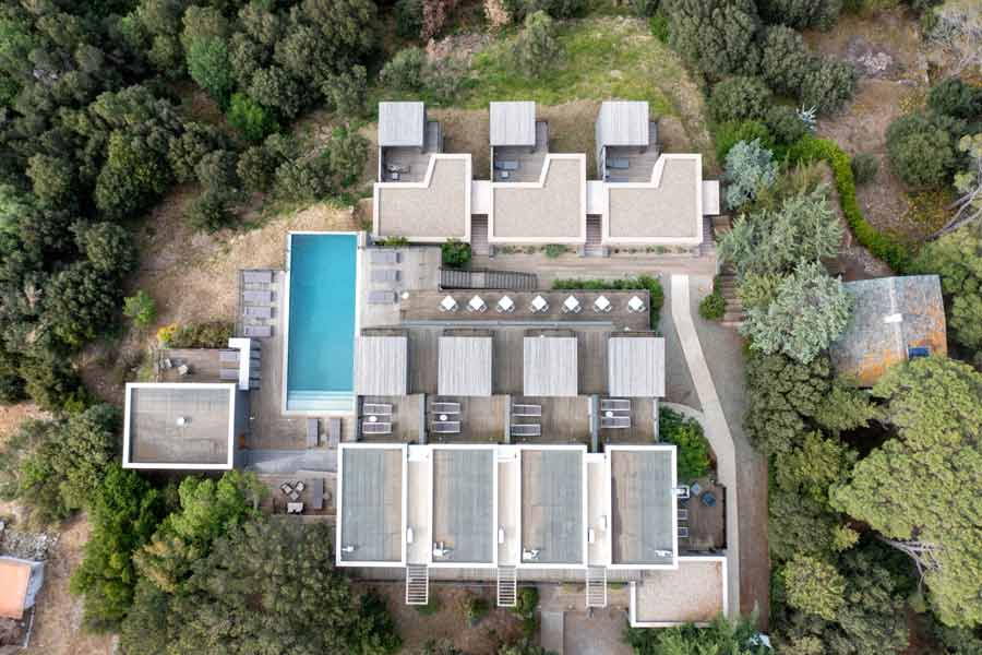 Vue aérienne de l’hôtel Le Tomino avec piscine et chambres nichées dans la nature du Cap Corse