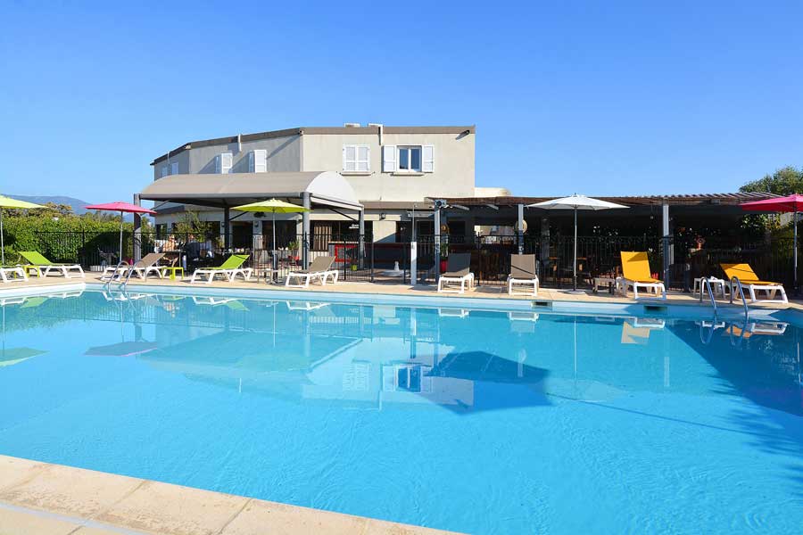 Hôtel Le Lido Piscine ensoleillée et terrasse de l’hôtel Le Lido avec transats et parasols, à moins de 10 minutes en voiture de l'aéroport de Bastia