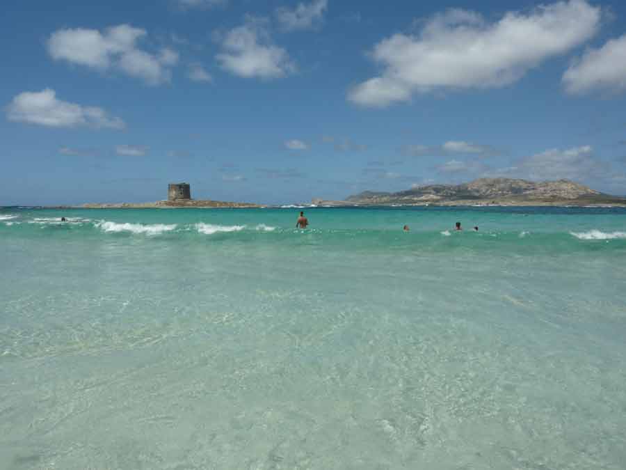 Eau cristalline et tour aragonaise en arrière-plan à la plage de La Pelosa à Stintino