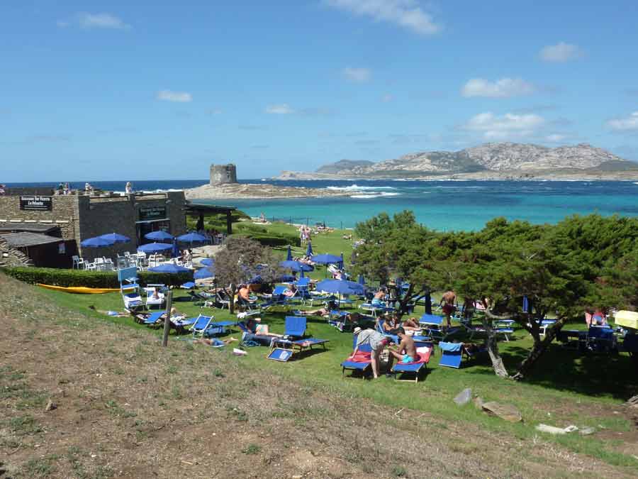Plage de La Pelosa à Stintino avec transats et vue sur la tour aragonaise en Sardaigne