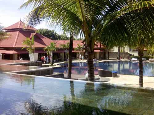 Piscine entourée de palmiers au Tamassa Bel Ombre, hôtel 4 étoiles à l’île Maurice