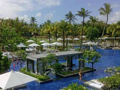 Grande piscine entourée de végétation et transats à l’hôtel Long Beach, île Maurice