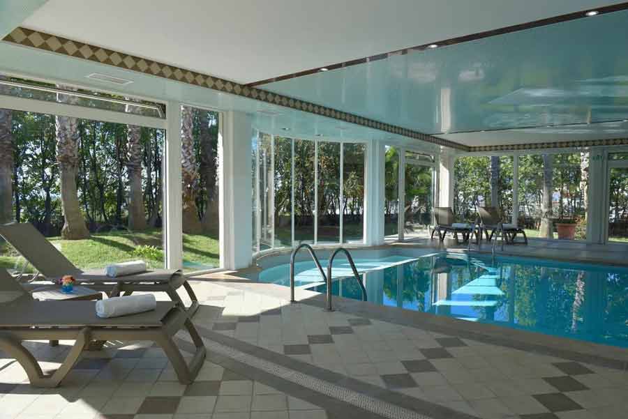 Piscine intérieure lumineuse avec transats à l’Ostella Spa & Resort, hôtel spa 4 étoiles à Bastia en Corse (hotel spa corse)