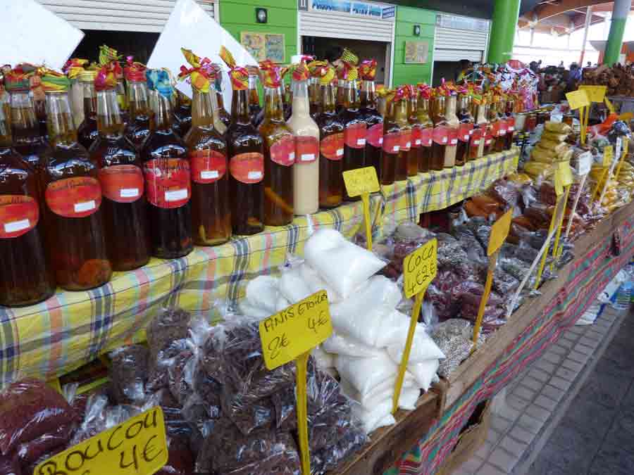 Étal de rhums arrangés et d’épices au marché de Basse-Terre en Guadeloupe