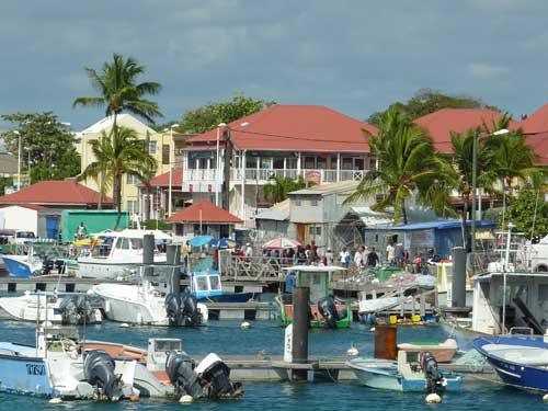 Bateaux amarrés dans le port de Saint-François en Guadeloupe, bordé de bâtiments aux toits rouges