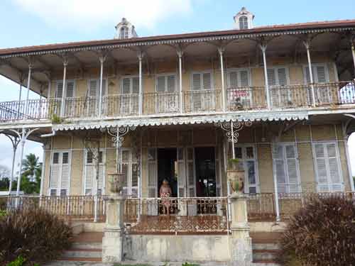 Détails architecturaux de la maison Zévallos en Guadeloupe avec balcon en ferronnerie et charme colonial