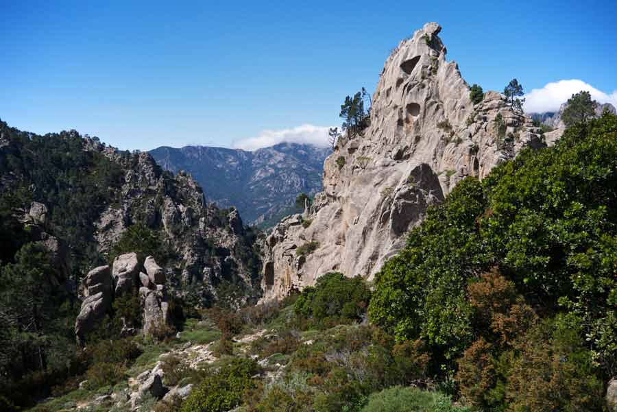 Paysage escarpé du GR20 sud entre Conca et Paliri, avec les roches sculptées et les montagnes verdoyantes de Corse