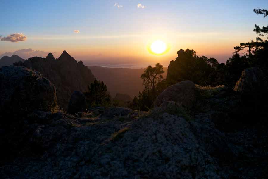 Lever de soleil depuis le refuge de Paliri sur les montagnes du GR20, avec vue sur les crêtes et la mer de Corse