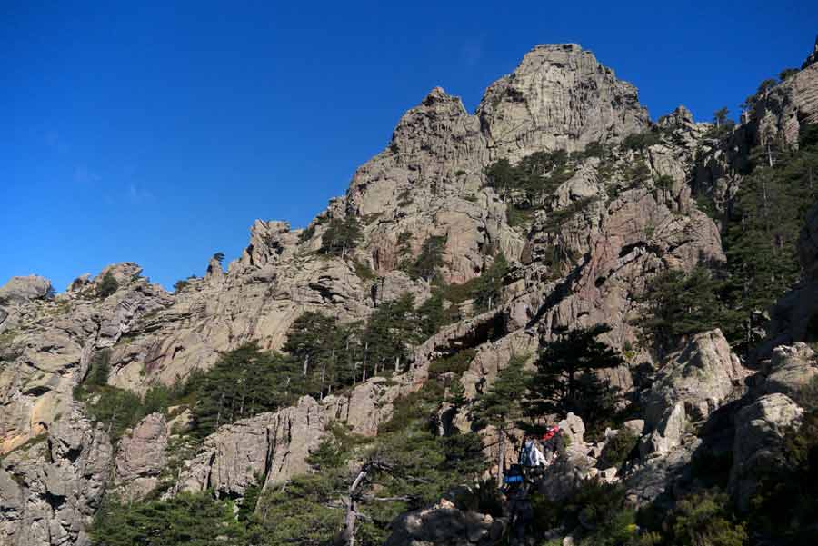 Randonneurs sur les pentes rocheuses du GR20 entre Paliri et les aiguilles de Bavella, dans le sud de la Corse