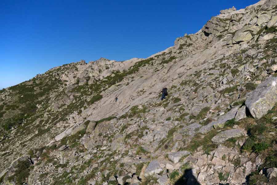 Randonneurs gravissant les pentes rocailleuses du Monte Incudine sur le GR20 sud, entre Asinau et Usciolu en Corse