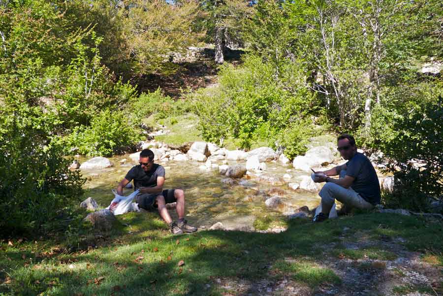 Randonneurs faisant une pause au bord d’un ruisseau sur le GR20 sud entre Asinau et Usciolu, en pleine nature corse