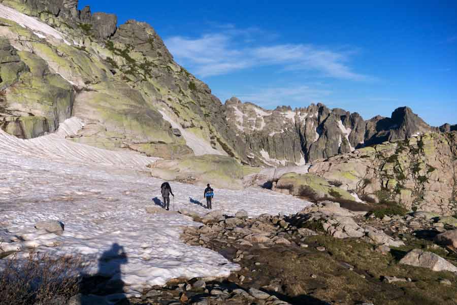 Marcheurs progressant sur la neige et les rochers du GR20 entre Petra Piana et Manganu, en Corse