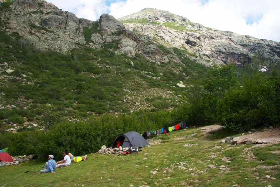 Campement de tentes au refuge de Manganu sur le GR20 en Corse, au pied des montagnes