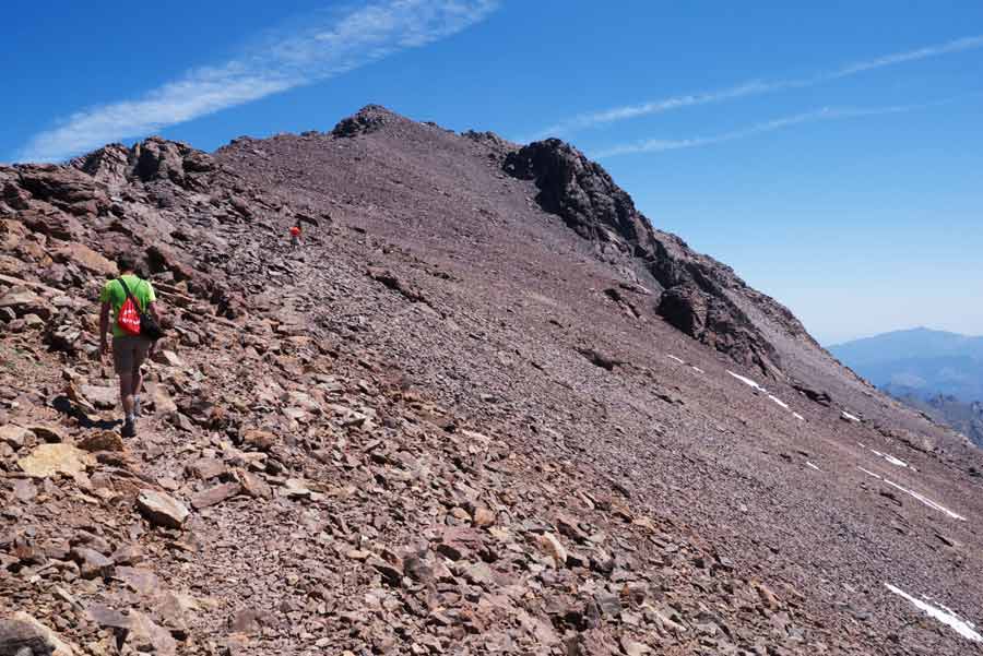 Randonneur sur la montée rocheuse du GR20 vers le Monte Cinto près de Ciottulu di i Mori en Corse