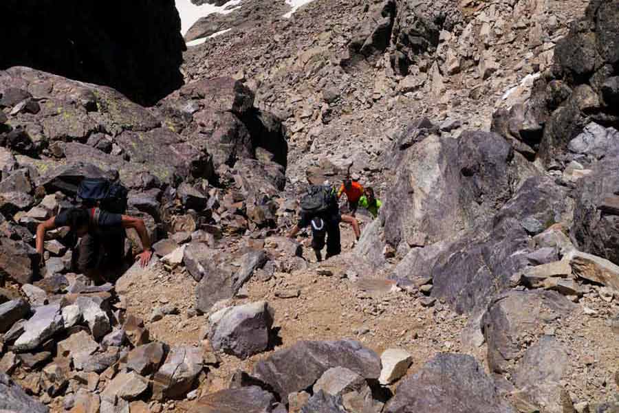 Randonneurs escaladant un passage rocheux sur le GR20 près du Monte Cinto en Corse