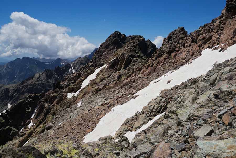 Neige et rochers sur les pentes du Monte Cinto sur le GR20 en Corse