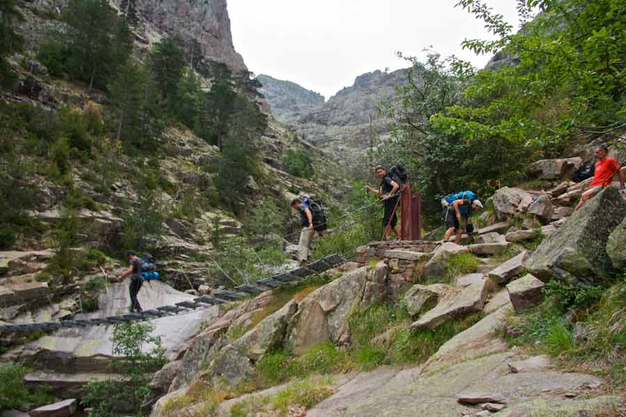 Randonneurs traversant les rochers sur le GR20 près de la passerelle de Spasimata en Corse