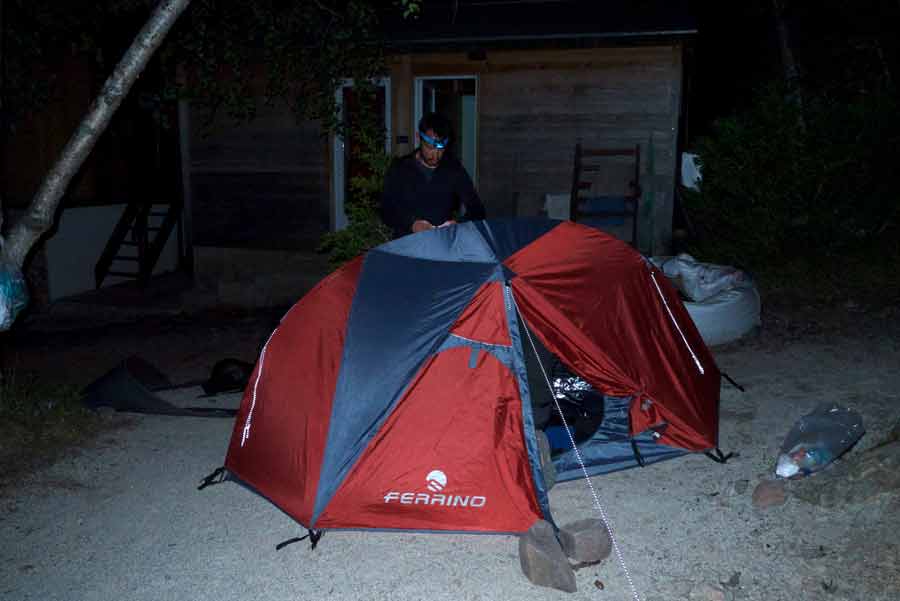 Randonneur qui sort en pleine nuit de sa tente Ferrino installée au refuge de Carrozzu pour attaquer la dernière étape du GR20 en Corse