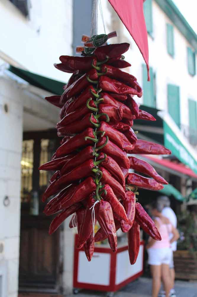 Chapelet de piments d’Espelette suspendus dans une rue du Pays basque (merkatu.fr), produit emblématique du terroir