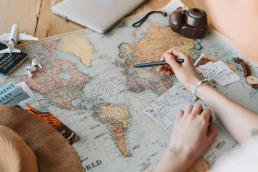 Préparation d'un voyage en couple sur une carte du monde vintage, avec passeport, appareil photo et accessoires de voyage