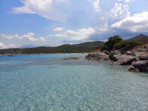 L'eau cristalline de la plage de Lodo, encadrée par les rochers et le maquis du désert des Agriates
