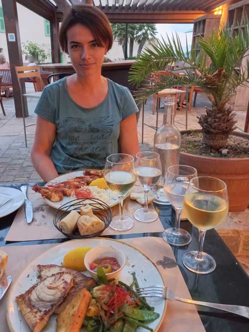 Dîner en terrasse à Erbalunga, poisson frais et verre de vin blanc corse au menu