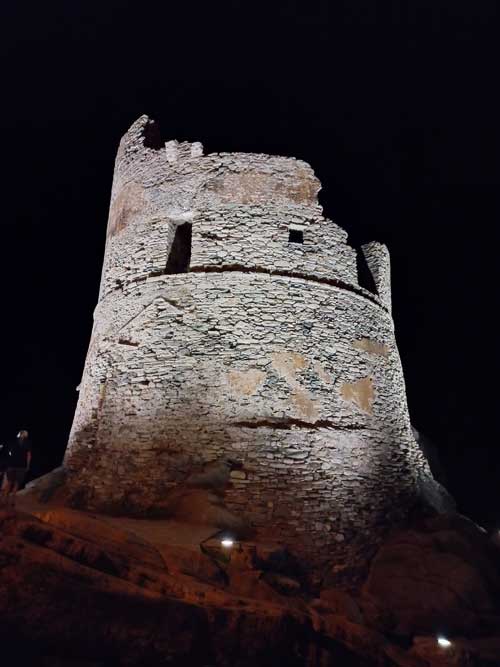La tour génoise d'Erbalunga illuminée dans la nuit, comme un décor de cinéma
