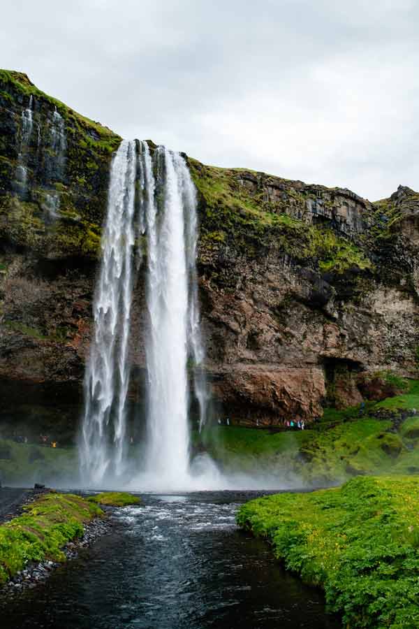 Cascade spectaculaire de Seljalandsfoss en Islande, falaise de basalte recouverte de mousse verte