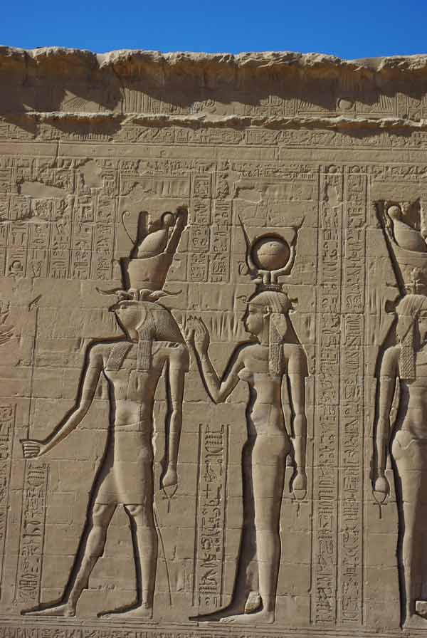 Bas-relief d'un temple égyptien représentant le dieu Horus à tête de faucon et une déesse coiffée du disque solaire, entourés de hiéroglyphes, découvert lors de notre circuit en Égypte