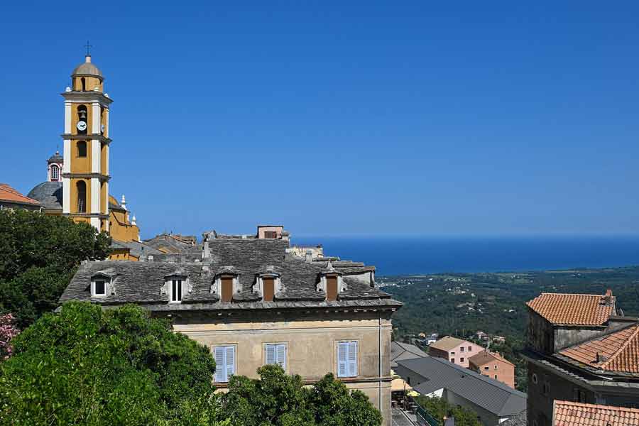 Village de Cervione et le clocher jaune de sa cathédrale Saint-Érasme dominant la Costa Verde et la mer Tyrrhénienne, idéal pour une escapade depuis un camping en bord de mer en Corse