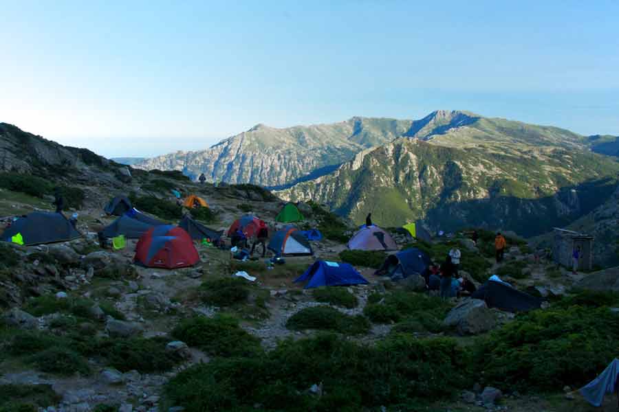 Tentes de randonneurs plantées près d’un refuge du GR20 en Corse, au pied des montagnes
